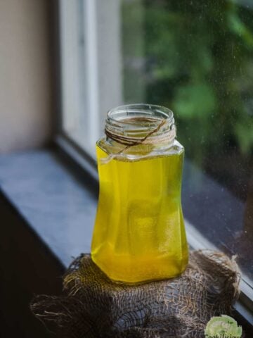 Vegan ghee in a jar placed on the window sill.