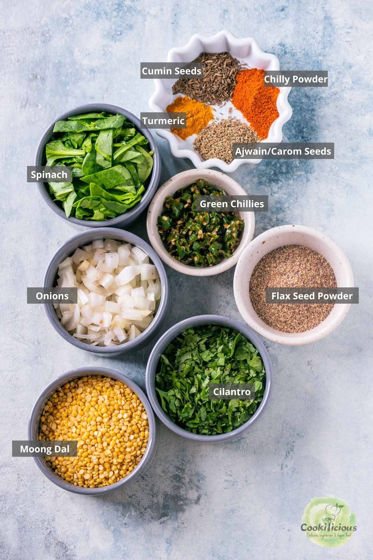 all the ingredients needed to make Moong Dal Chilla placed on a table with labels on them.