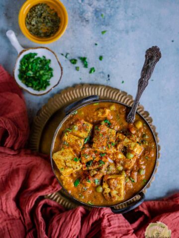 Matar Paneer served in a bowl with a spoon