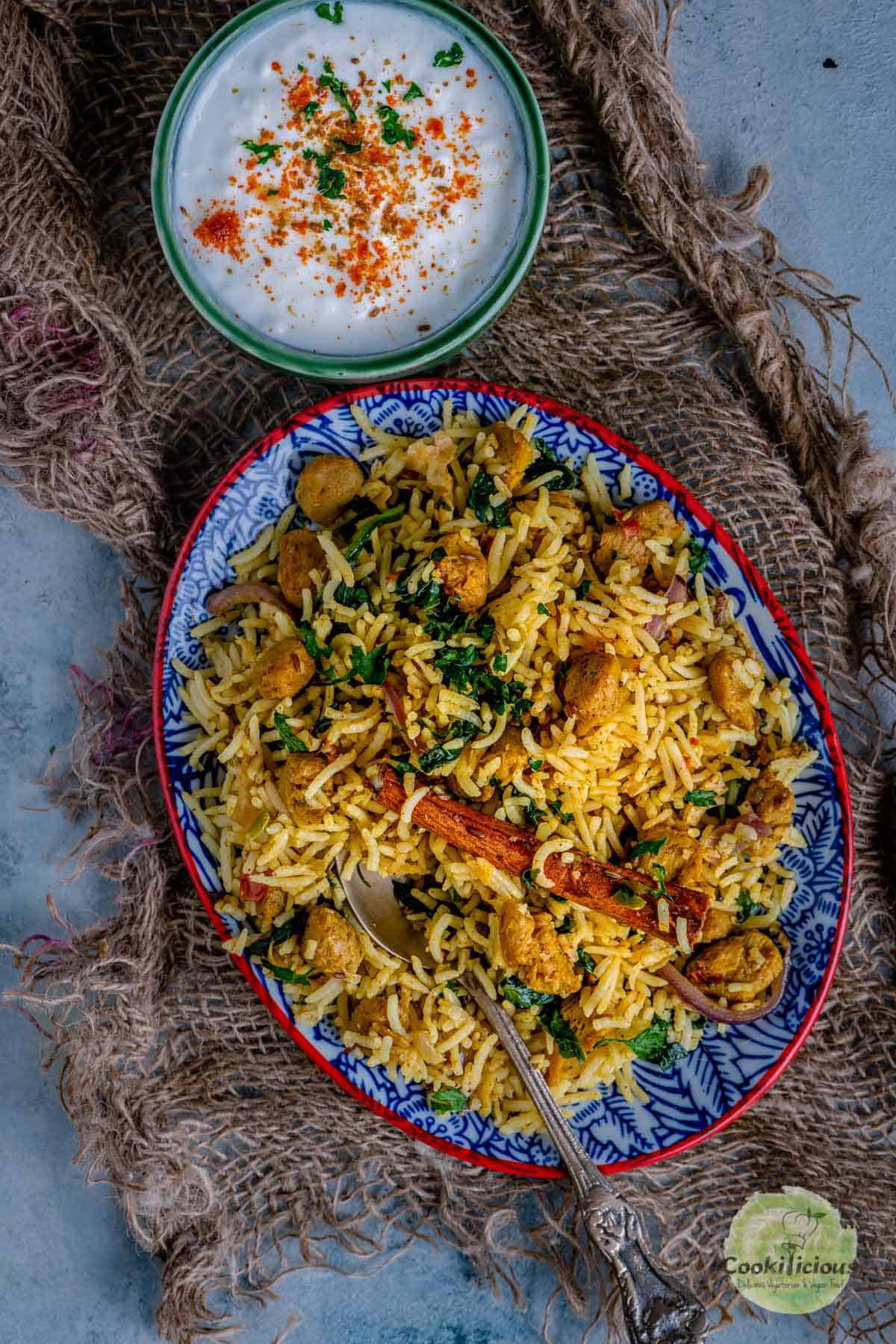 Soya Chunks Pulao served with a bowl of raita on the side