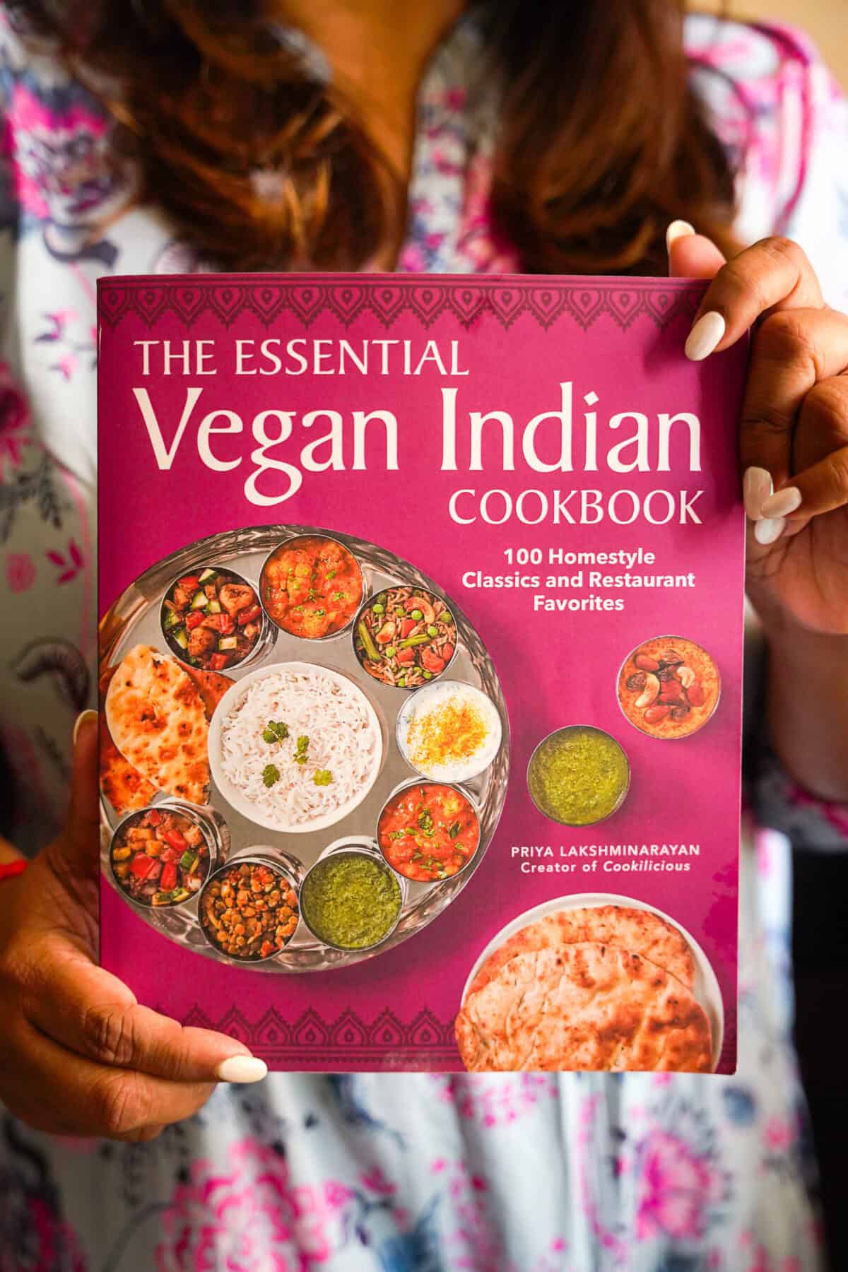 Priya holding her cookbook.