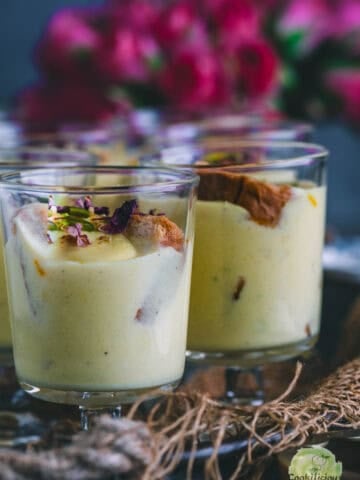 Instant Rabdi Cheesecake topped with saffron strands and pistachios - a creamy Indian fusion dessert made with ricotta cheese and a crunchy rusk base.